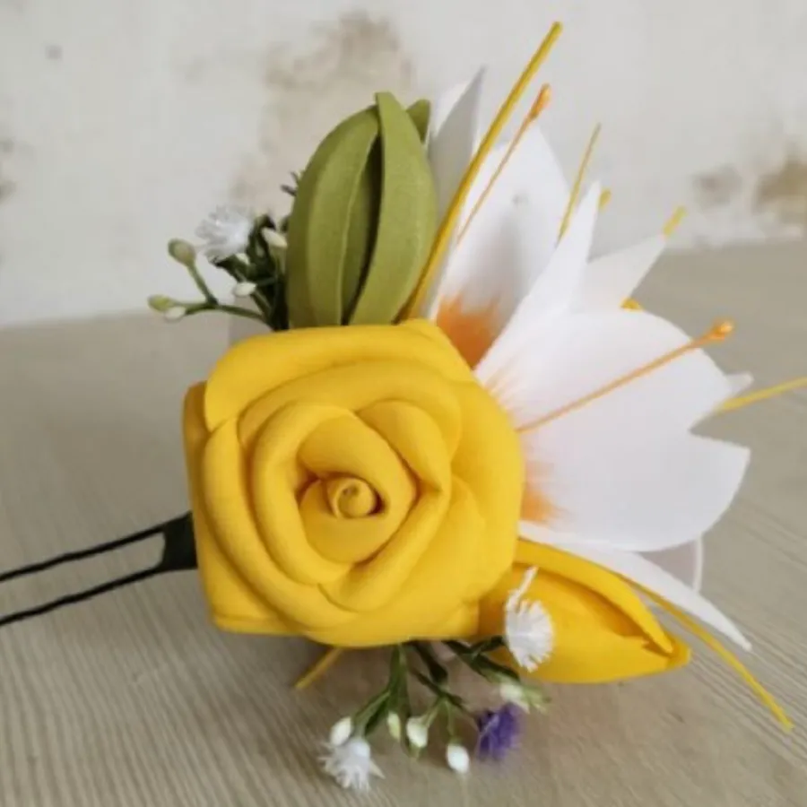 A handmade fabric flower brooch in yellow and white